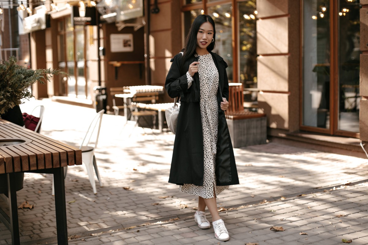 fulllength-portrait-brunette-asian-woman-midi-white-dress-black-trench-coat-stands-outside-near-street-cafe (1)